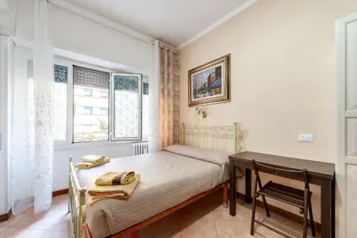 a small bedroom with a bed and a desk at Vatican Mami in Rome