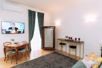 a living room with a table and a tv on the wall at Duke's Apartment in Rome