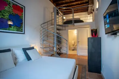 a bedroom with a bed and a spiral staircase at PgrHome Domus Pantheon in Rome