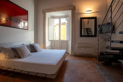 a bedroom with a white bed and a staircase at PgrHome Domus Pantheon in Rome