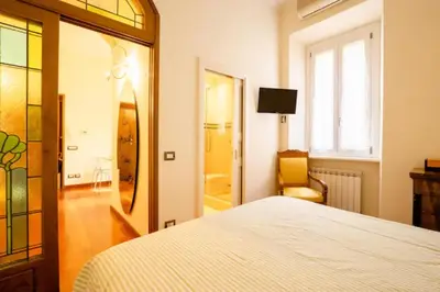 a bedroom with a bed and a mirror and a chair at La Petite Maison Piave in Rome