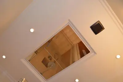 a bathroom with a mirror on the ceiling at La Petite Maison Piave in Rome