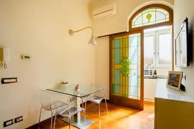a dining room with a glass table and a stained glass window at La Petite Maison Piave in Rome