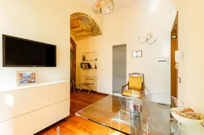 a living room with a glass table and a television at La Petite Maison Piave in Rome