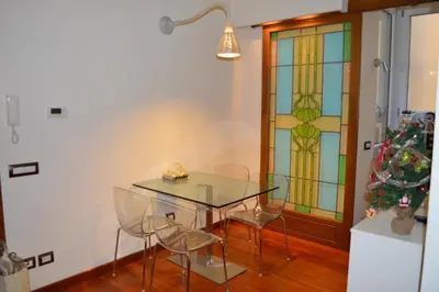 a dining room with a glass table and a stained glass window at La Petite Maison Piave in Rome
