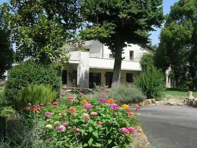 a white house with flowers in front of it at Relais La Canfora in Rome