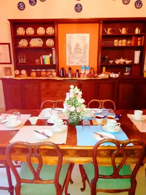 a wooden table with chairs and flowers on it at Relais La Canfora in Rome