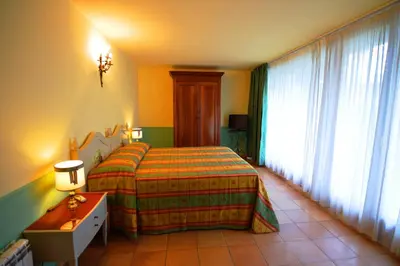 a bedroom with a bed and a table and a window at Relais La Canfora in Rome