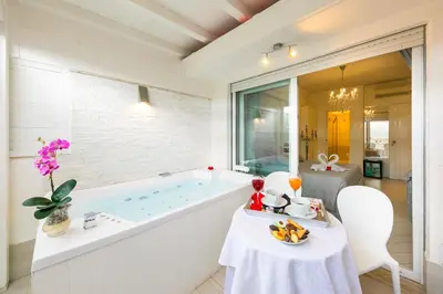 a bathroom with a tub and a table with food on it at Suites Roma Tiburtina in Rome