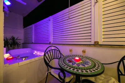 a table with chairs and a tub in a room at Suites Roma Tiburtina in Rome