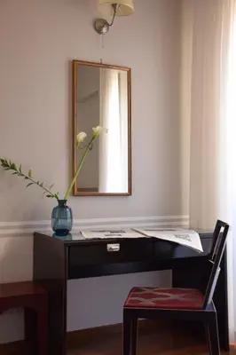 a desk with a mirror and a vase with a plant at Hotel Lancelot in Rome