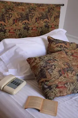 a book and a remote control on a bed at Hotel Lancelot in Rome