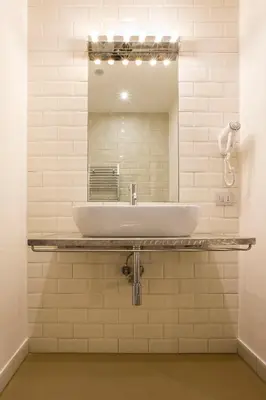a bathroom with a sink and a mirror at Trevi Contemporary Suite in Rome