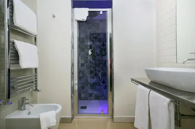 a bathroom with a shower with a sink and a toilet at Trevi Contemporary Suite in Rome