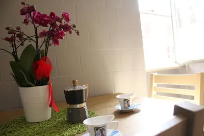 a table with two cups and a vase with flowers at Apartment Flaminio in Rome