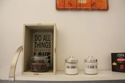 a shelf with a do all things box and jars at Apartment Flaminio in Rome