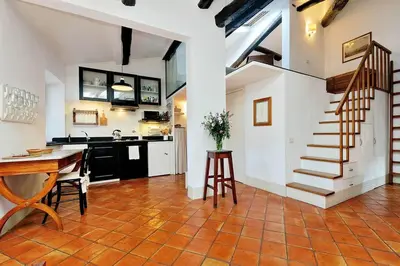 a kitchen and dining room with a table and a staircase at Trastevere Charming Loft | Romeloft in Rome