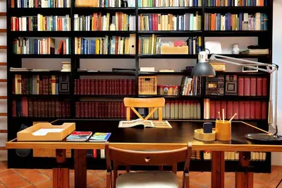 a book shelf filled with books with a desk at Trastevere Charming Loft | Romeloft in Rome