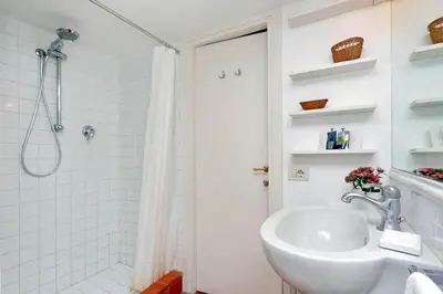 a white bathroom with a sink and a shower at Trastevere Charming Loft | Romeloft in Rome