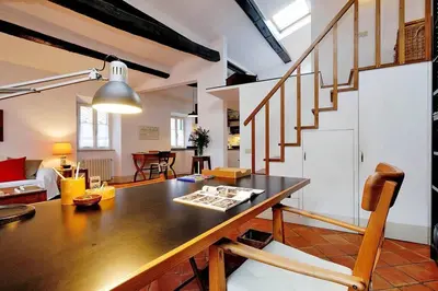a living room with a wooden table and stairs at Trastevere Charming Loft | Romeloft in Rome