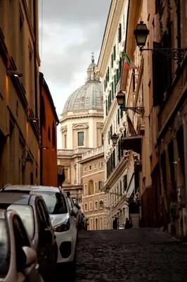 a street with cars parked on the side of a building at Accogliente Appartamento al Colosseo in Rome