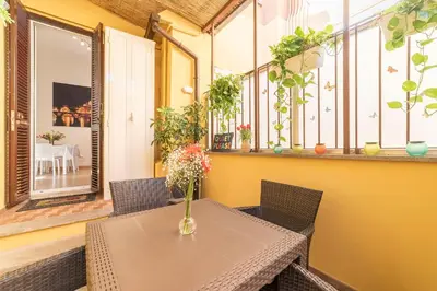 a table with a vase of flowers on a balcony at Accogliente Appartamento al Colosseo in Rome
