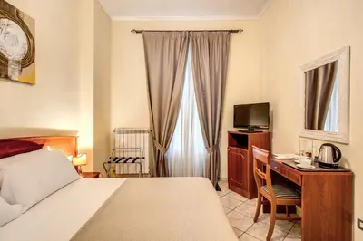 a hotel room with a bed and a desk with a computer at Residenza Praetoria in Rome