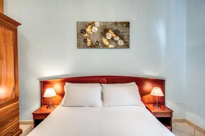 a bedroom with a white bed with two night stands at Residenza Praetoria in Rome