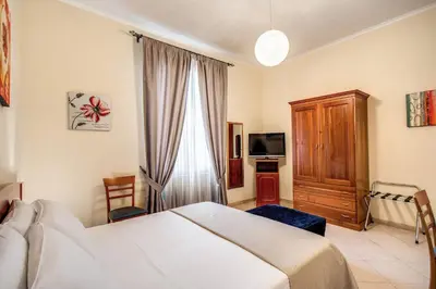 a hotel room with a bed and a tv at Residenza Praetoria in Rome