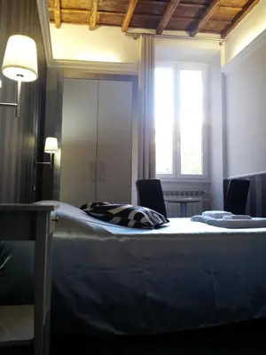 a bedroom with a bed with two chairs and a window at Navona Nice Room in Rome