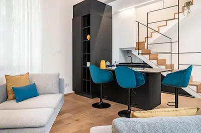 a living room with a couch and a table with blue chairs at Casa Scalzi in Rome