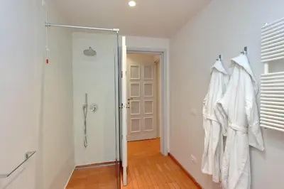 a bathroom with a shower and a robe hanging on a wall at Residenza Torre Vecchiarelli - apt 3 in Rome