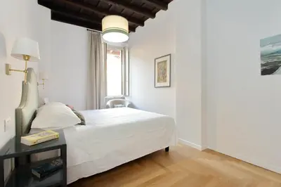 a white bedroom with a bed and a table at Residenza Torre Vecchiarelli - apt 3 in Rome