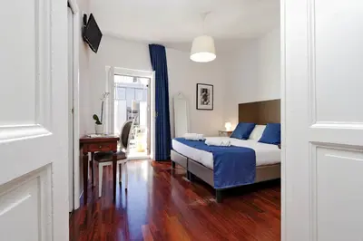 a bedroom with a bed and a table and a desk at Midnight in Rome Guest House in Rome