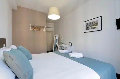 a bedroom with a large white bed with blue pillows at Midnight in Rome Guest House in Rome