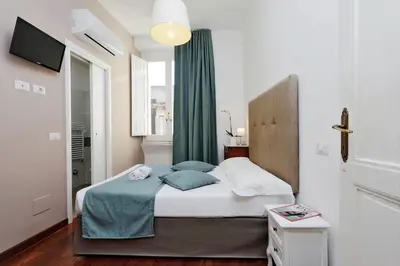 a bedroom with a bed with a green curtain at Midnight in Rome Guest House in Rome