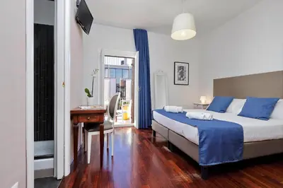 a bedroom with a bed and a desk and a window at Midnight in Rome Guest House in Rome