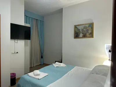 a hotel room with a bed and a flat screen tv at Guesthouse Alex II in Rome