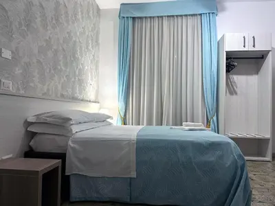 a bedroom with a bed with a blue blanket at Guesthouse Alex II in Rome