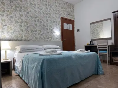 a bedroom with a bed with a blue blanket at Guesthouse Alex II in Rome