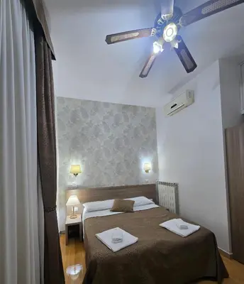 a bedroom with a bed and a ceiling fan at Guesthouse Alex II in Rome