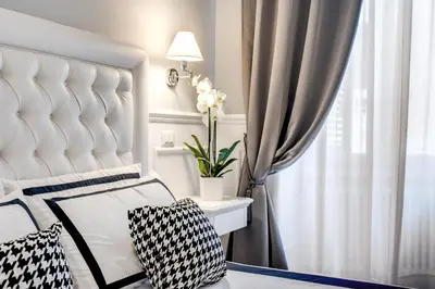a white bedroom with a white bed and a chair at Piazza di Spagna Just for Us in Rome