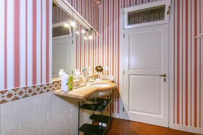 a bathroom with a sink and a mirror and a door at Pantheon Palazzo Nari in Rome