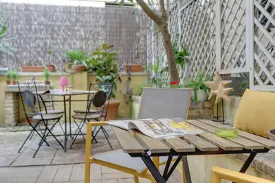 a patio with a table with a newspaper on it at Colosseo Secret Garden - Home and More in Rome