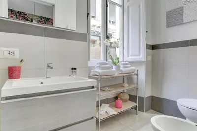 a bathroom with a sink and a tub and a toilet at Colosseo Secret Garden - Home and More in Rome