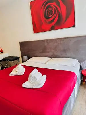 a red bed with towels on it with a painting at Vatican Modern Apartments KALASA in Rome