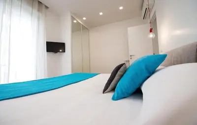 a bedroom with a white bed with blue pillows at Vatican Modern Apartments KALASA in Rome