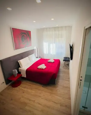 a bedroom with a red bed with a red blanket at Vatican Modern Apartments KALASA in Rome