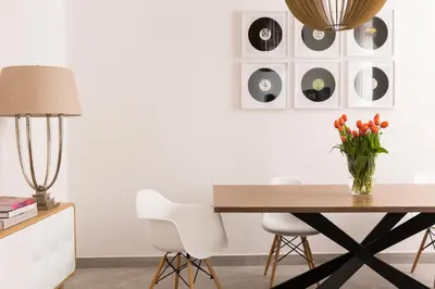 a desk with a vase of flowers and a lamp at Maison Letizia Roma in Rome