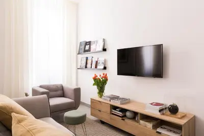 a living room with a television on a wall at Maison Letizia Roma in Rome